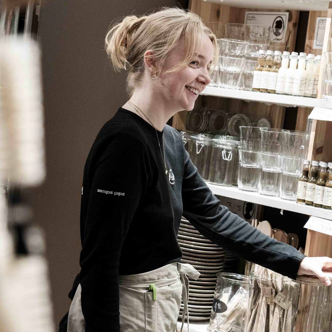 Imødekommende medarbejder fra Søstrene Grene på Nørrebro står foran pæne glas.